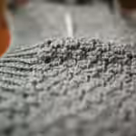 person holding gray knit textile