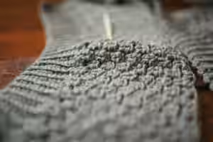 person holding gray knit textile